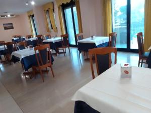 ein Esszimmer mit Tischen, Stühlen und Fenstern in der Unterkunft Campus Hotel in Bari