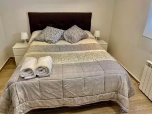 a bedroom with a large bed with towels on it at Chalet Medina del Campo entrepinares in El Campillo