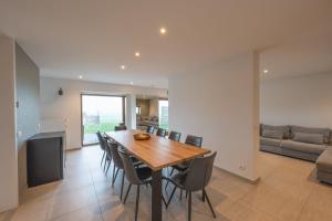 a dining room and living room with a table and chairs at De Ast by De Oude Kaasmakerij in Passendale