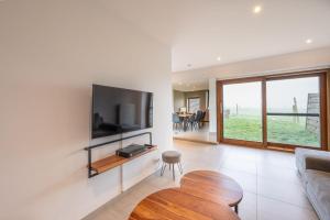 a living room with a flat screen tv on a wall at De Ast by De Oude Kaasmakerij in Passendale