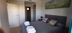 una camera da letto con un letto con asciugamani sopra di Isla Canela -APARTAMENTO LOS FLAMENCOS a Isla Canela Altre 13 foto