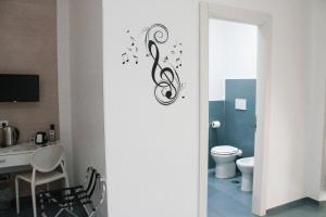a bathroom with a toilet and a sign with music notes at Mascalzone latino luxury rooms in Naples
