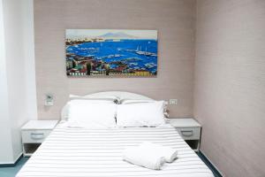 een slaapkamer met een wit bed en een schilderij aan de muur bij Mascalzone latino luxury rooms in Napels