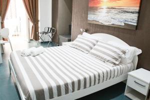 een slaapkamer met een groot bed met gestreepte lakens en kussens bij Mascalzone latino luxury rooms in Napels