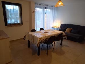 sala de estar con mesa con sillas y sofá en Appartement Les Vallons au pied des pistes en Ancelle