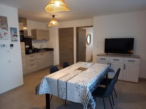 a kitchen with a table with chairs and a television at Appartement Les Vallons au pied des pistes in Ancelle