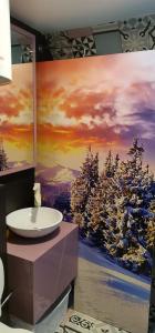 a bathroom with a sink and a painting of trees at Dvoetažni apartman NEW YORK in Jahorina +33 photos
