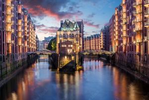 ハンブルクにあるホテル ヴィレッジの建物と橋のある都市の川