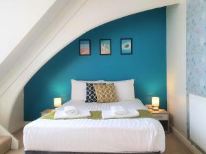 a bedroom with a large bed with a blue wall at Central Apartments - Spacious 2 Beds in Swindon