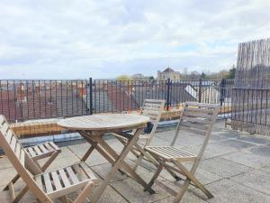 a wooden table and two chairs on a roof at Central Apartments - Spacious 2 Beds in Swindon