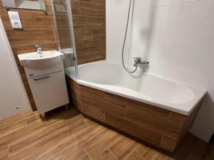 a bathroom with a bath tub and a sink at 22 Kąty in Radziemice