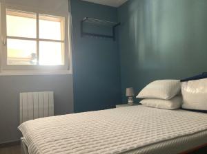 een slaapkamer met een wit bed en een raam bij Superbe appartement restauré avec vue sur mer. in Wimereux