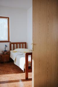 a bedroom with a bed and a wooden door at House Diminić in Labin