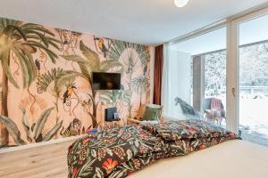 ein Schlafzimmer mit einem Bett mit einer tropischen Tapete in der Unterkunft Apartment Rio in Winterberg