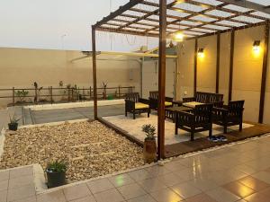 an outdoor patio with chairs and a table and a table and chairs at Sunset Alula Villa- العلا in Ar Riḩāb