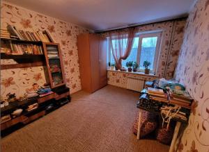 sala de estar con estante de libros y ventana en Kamok Sanniy, en Coasta