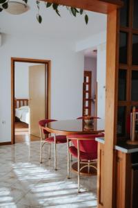 a dining room with a table and red chairs at House Diminić in Labin
