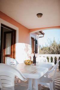 a white table with white chairs and a bottle of wine at House Diminić in Labin