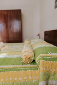 a bed with a green comforter with pillows on it at House Diminić in Labin