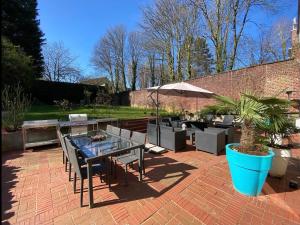 a patio with a table and chairs and an umbrella at Le jacuzzi de Marie in Tourcoing