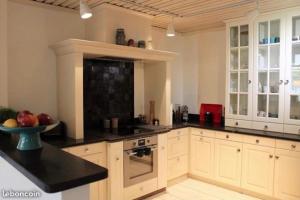 a large kitchen with white cabinets and black counter tops at Le jacuzzi de Marie in Tourcoing