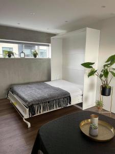 ein Schlafzimmer mit einem Bett und einem Tisch darin in der Unterkunft Modern Apartment With City & Oceanside View in Tórshavn