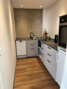 a kitchen with white cabinets and a counter top at Modern Apartment With City & Oceanside View in Tórshavn