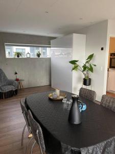 ein Wohnzimmer mit einem Tisch und Stühlen sowie eine Küche in der Unterkunft Modern Apartment With City & Oceanside View in Tórshavn