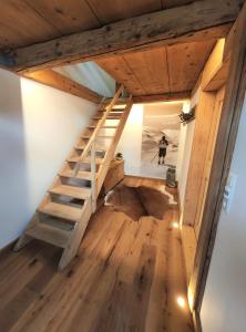 um quarto com uma escada de madeira numa pequena casa em Landhaus im Allgäu em Halblech