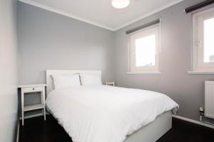 a bedroom with a white bed and two windows at 2 DoubleBed Rooms Flat Aberdeen City, near University in Aberdeen