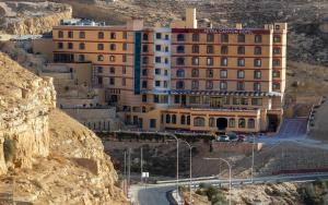 un bâtiment sur le côté d'une montagne dans l'établissement Petra Canyon Hotel, à Wadi Musa