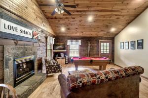 a living room with a fireplace and a pool table at Love Shack in Sevierville