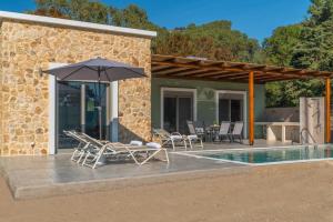 un patio con sillas y una sombrilla junto a la piscina en Oliveto A Flumine - Experientia Villa, en Pastida