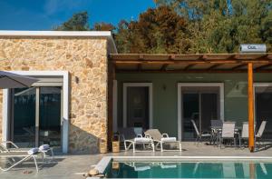 a house with a swimming pool and a patio at Oliveto A Flumine - Experientia Villa in Pastida