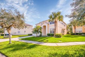 a home with palm trees and a sidewalk at Large 6BR Themed Family Villa Near Disney world in Kissimmee