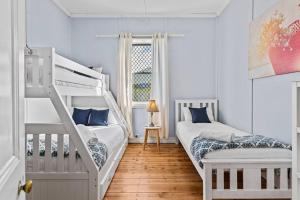 a bedroom with two bunk beds and a window at HOLIDAYS ON LOVE STREET / HUNTER VALLEY in Cessnock