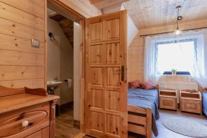 a bedroom with a bed and a window and a door at PUSTELNIA WODZA in Wisła
