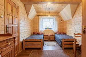 a small room with two beds and a window at PUSTELNIA WODZA in Wisła