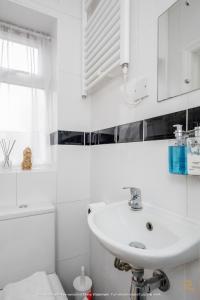 a white bathroom with a sink and a toilet at Enfield House by Svelte Living in Enfield