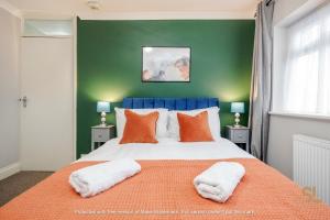 a bedroom with a large bed with orange pillows at Enfield House by Svelte Living in Enfield