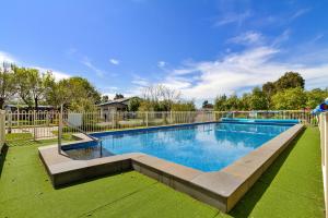 a swimming pool in a yard next to a fence at Traralgon Holiday Village in Traralgon