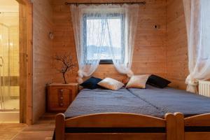 a bed in a wooden room with a window at PUSTELNIA WODZA in Wisła