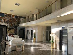 een grote lobby met witte stoelen en een trap bij Departamento Santos Dumont Punta del Este in Punta del Este