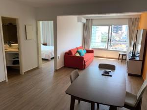 sala de estar con sofá rojo y mesa en Departamento Santos Dumont Punta del Este, en Punta del Este