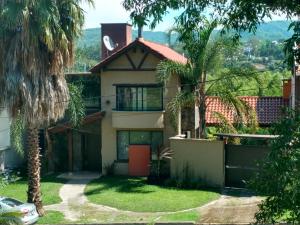 una casa con palmeras delante en Homestays La Reinamora en San Salvador de Jujuy