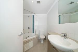 a white bathroom with a sink and a toilet at Bella Mare - 2 Bedroom Ocean View Terrace Apt in Ettalong Beach