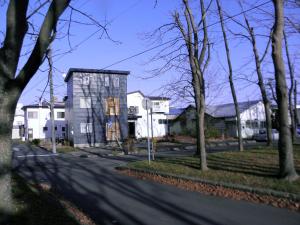 a house on the side of a street with trees at Guest House Annabel in Hakodate