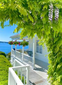 een wit huis met een veranda met bloemen erop bij Orcas Hotel in Orcas