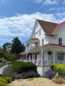 a white house with flowers on the front of it at Orcas Hotel in Orcas