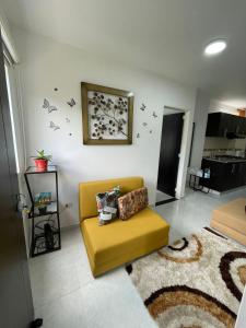 a living room with a yellow couch and a rug at Apartaestudio San Gil - Hostal Green in San Gil
